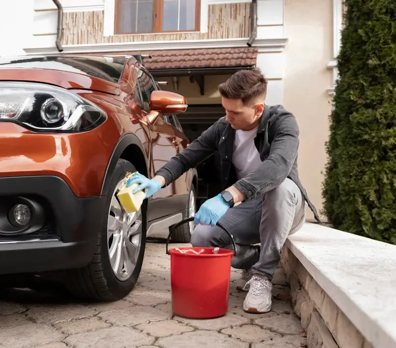 Lavage auto à domicile Castelnau-Valence : professionnel intervenant sur un véhicule